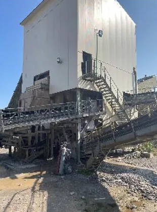 Bâtiment logant un équipement de type concasseur ou crible pour une carrière d'extractiion minérale traité intégralement avec des panneaux et bardages acoustiques