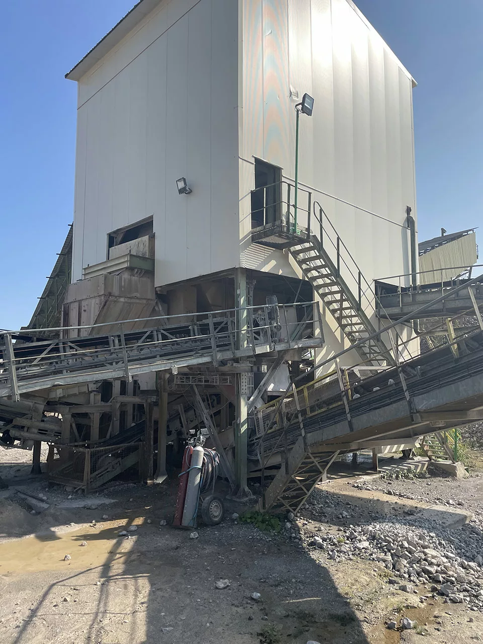 Bâtiment logant un équipement de type concasseur ou crible pour une carrière d'extractiion minérale traité intégralement avec des panneaux et bardages acoustiques